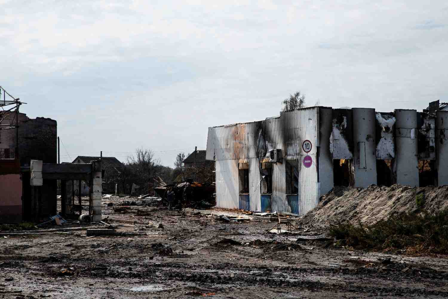 Fire-damaged commercial property with blackened siding and structural ruin.