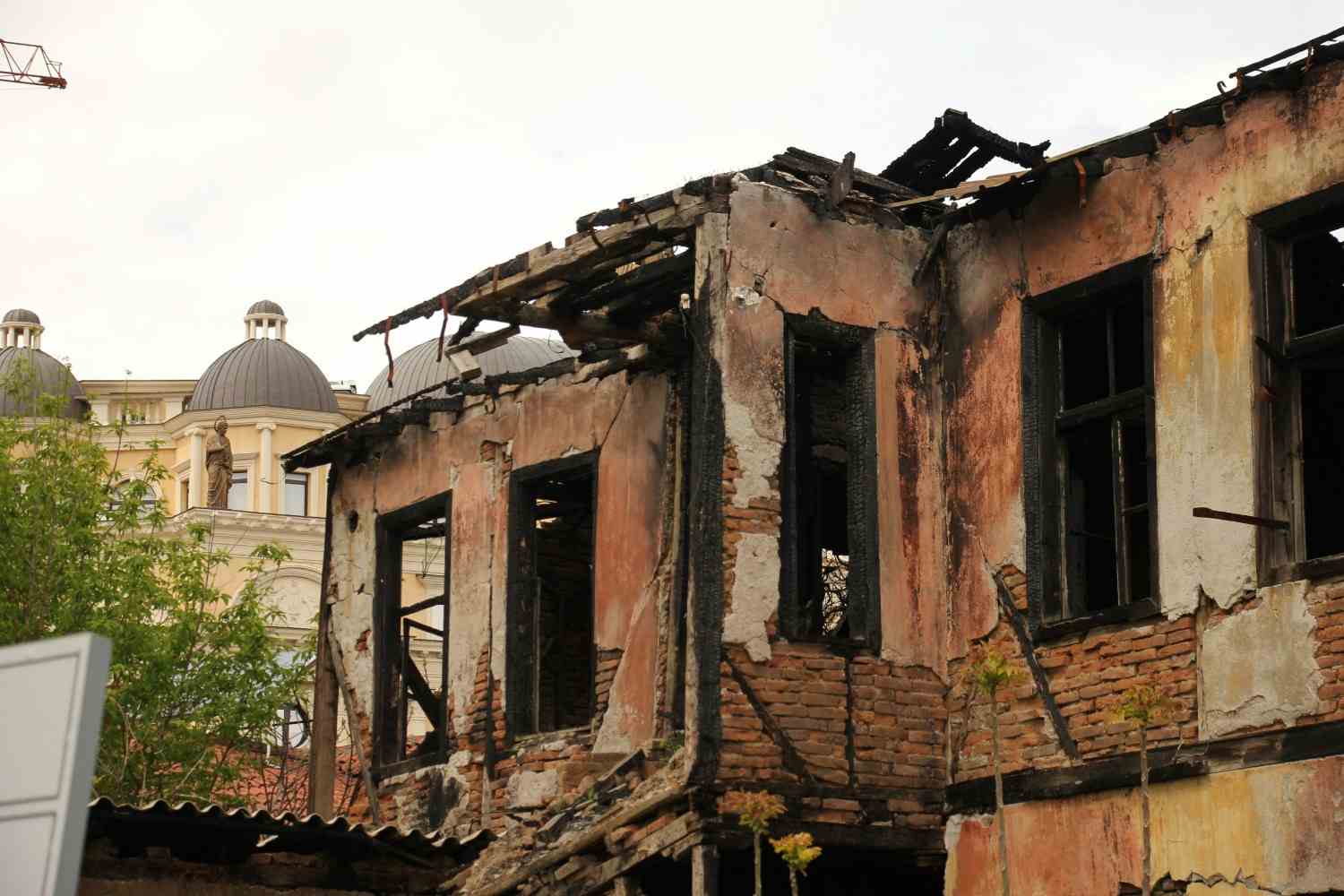 Severe property fire damage showing charred wooden roof beams on a Waldorf brick building