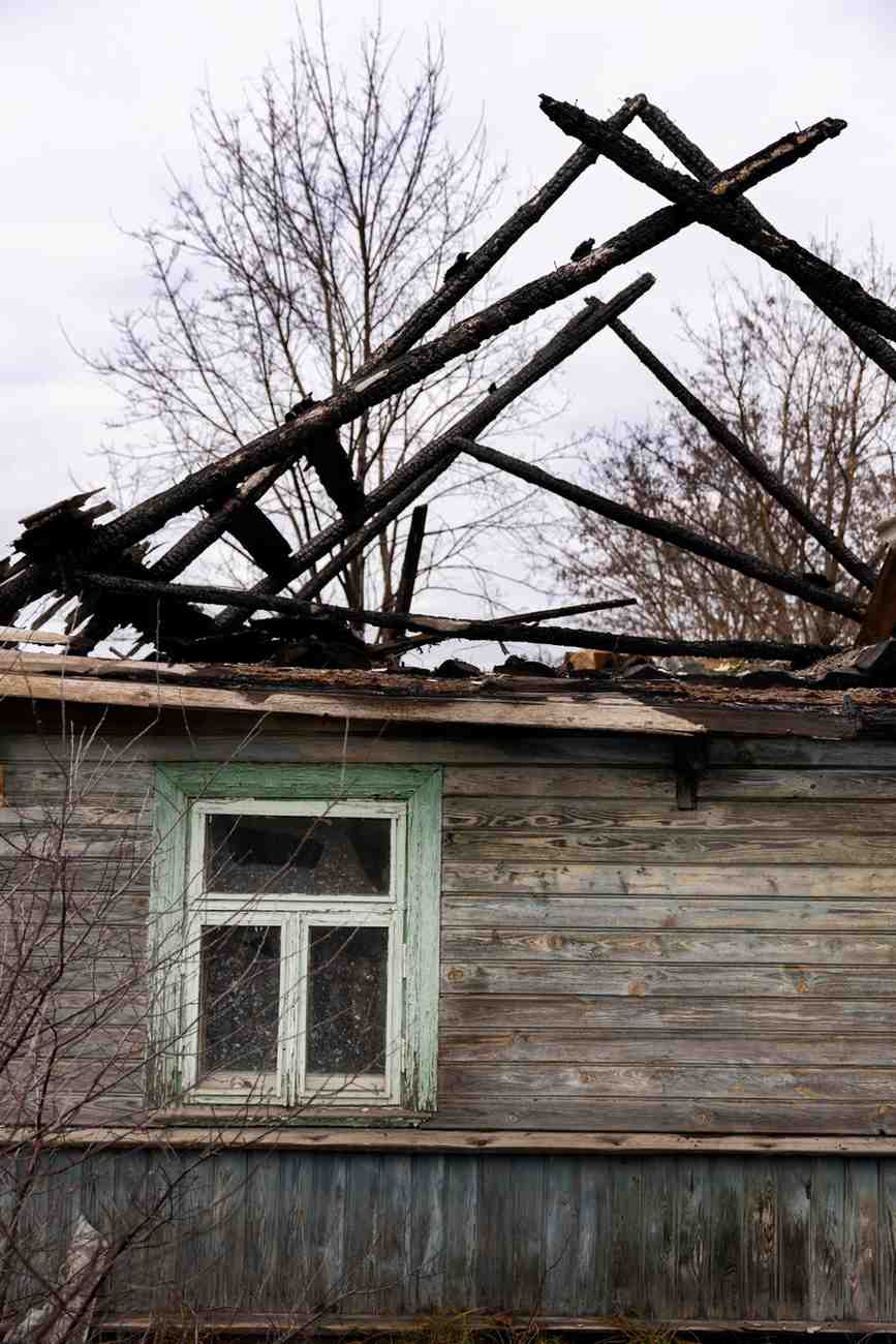Charred wooden roof frame of a water and fire damaged home.