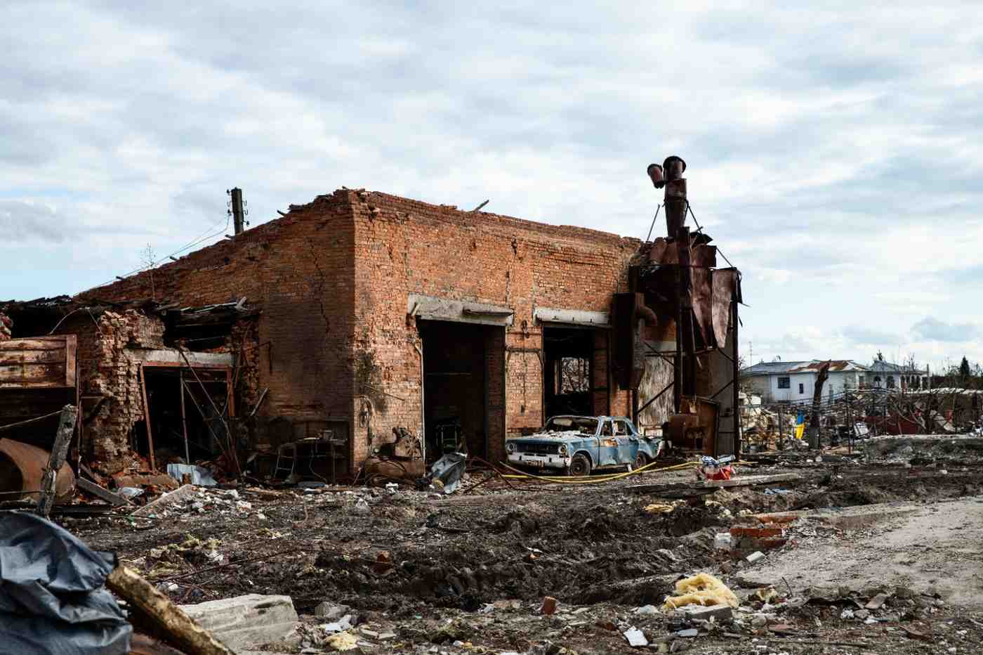Destroyed commercial brick property showing severe fire damage and a collapsed roof.
