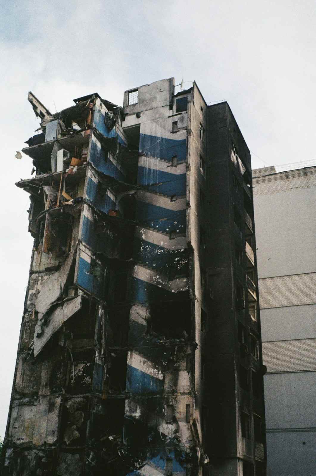 Severe structural fire damage showing a collapsed corner of a high-rise residential building.
