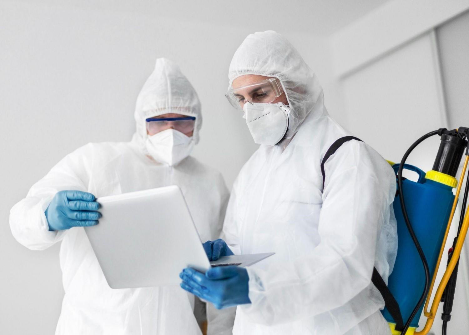 Certified mold remediation technicians in protective suits reviewing inspection findings before starting mold removal in a Maryland property.
