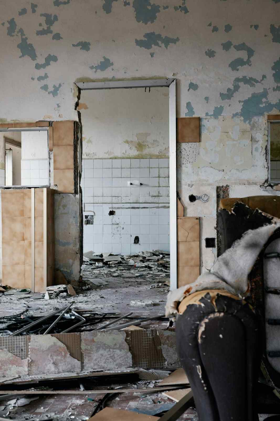 Severe indoor water damage showing peeling paint and ruined floors needing restoration in Columbia, MD.