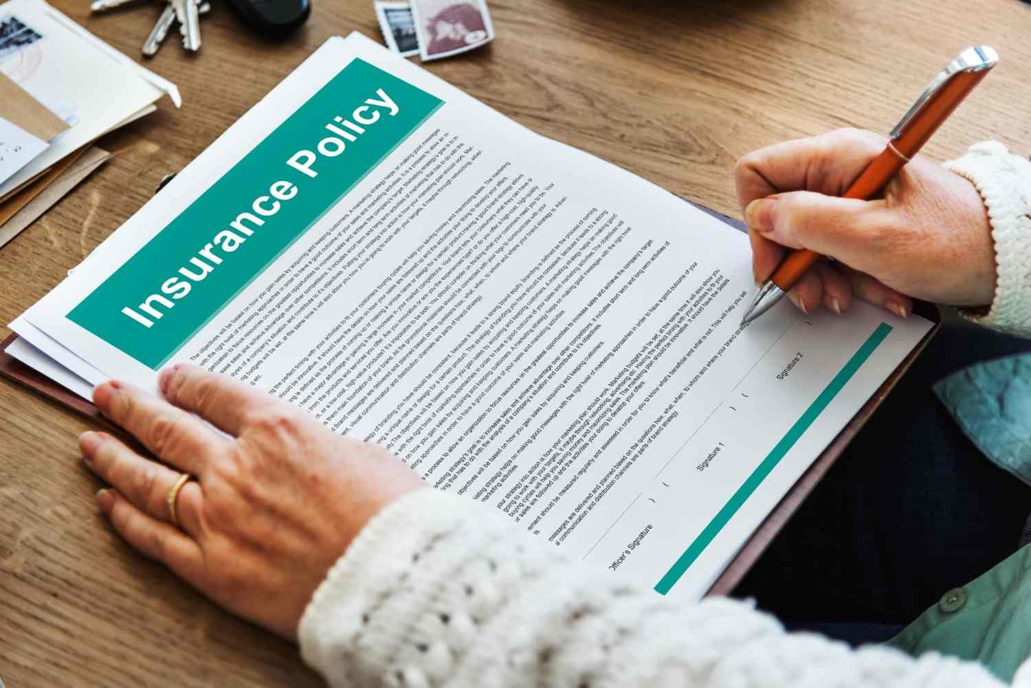 Person reviewing and signing an insurance policy for water and fire damage coverage