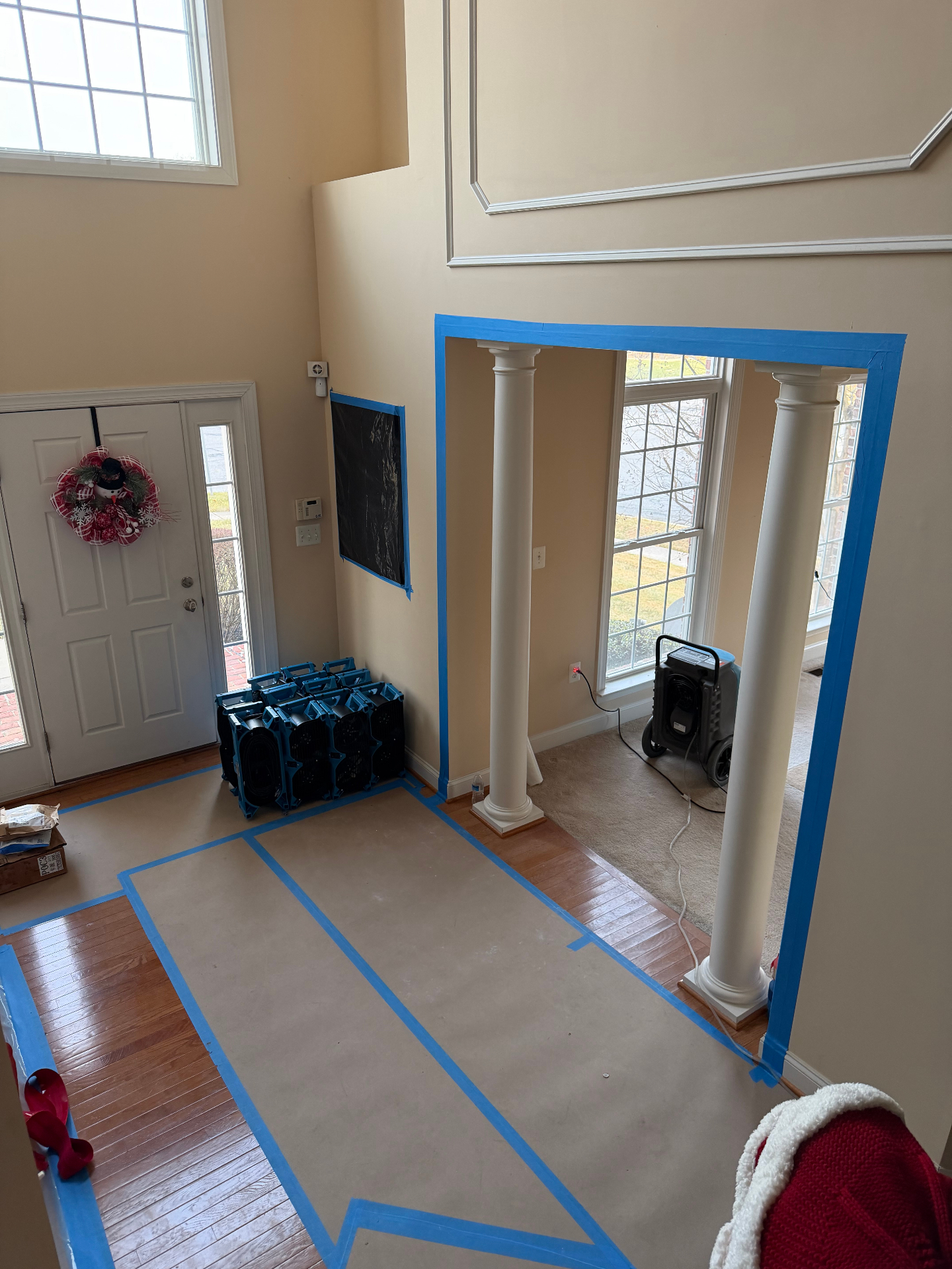 Water damage containment – entryway with air movers and protective barriers