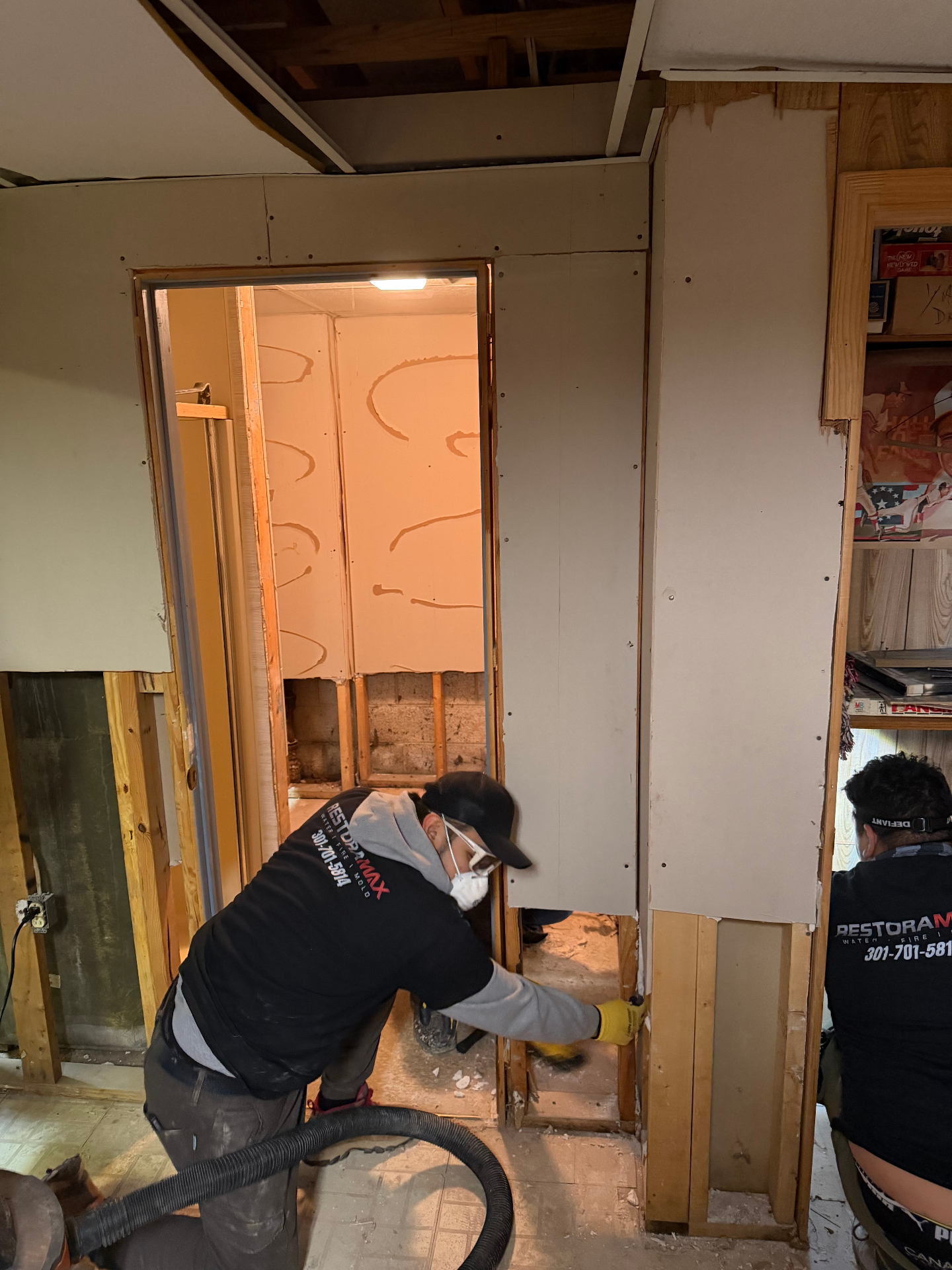 Restoration crew performing drywall removal and cleanup