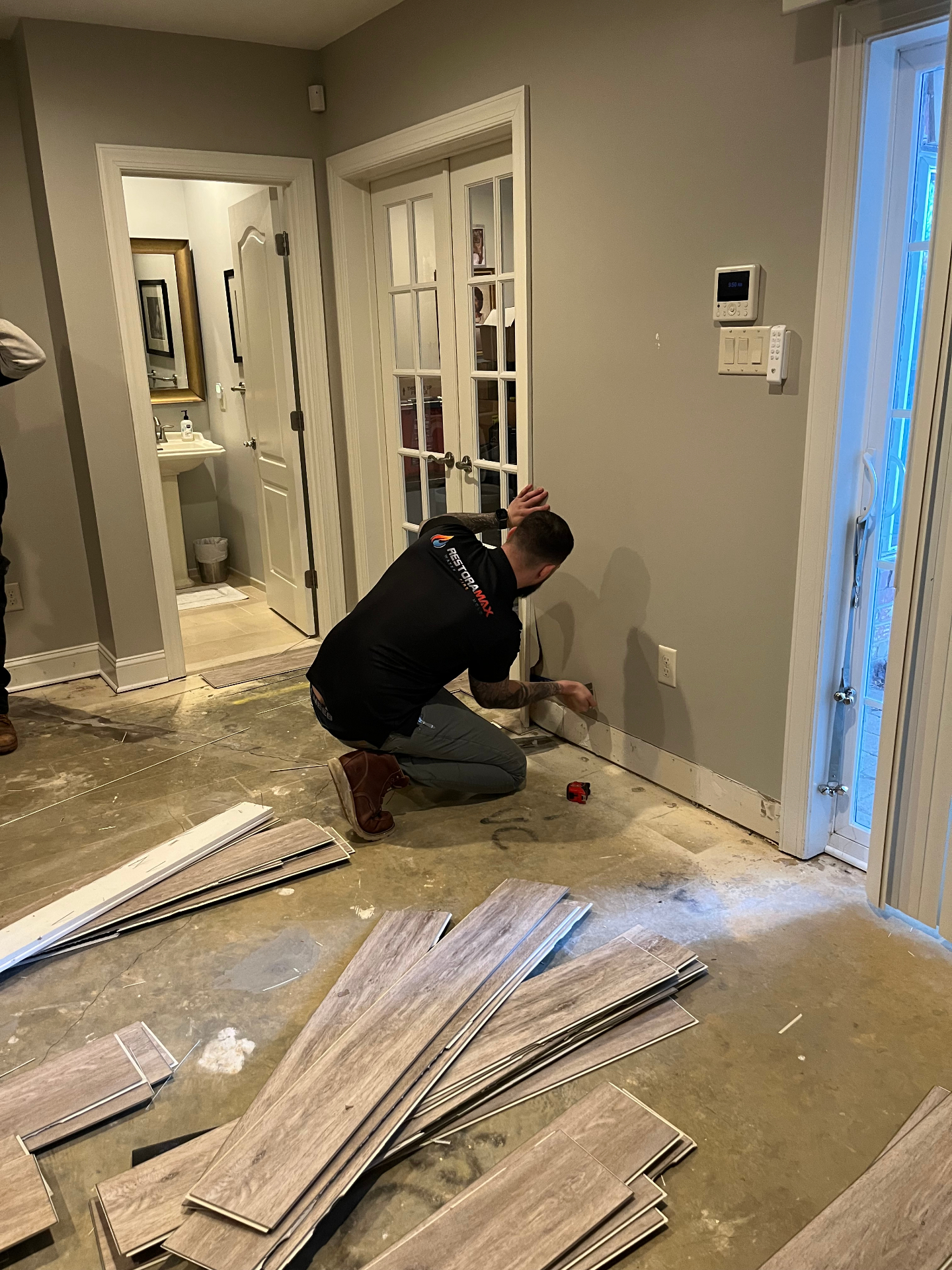 Technician installing new flooring after water damage repair
